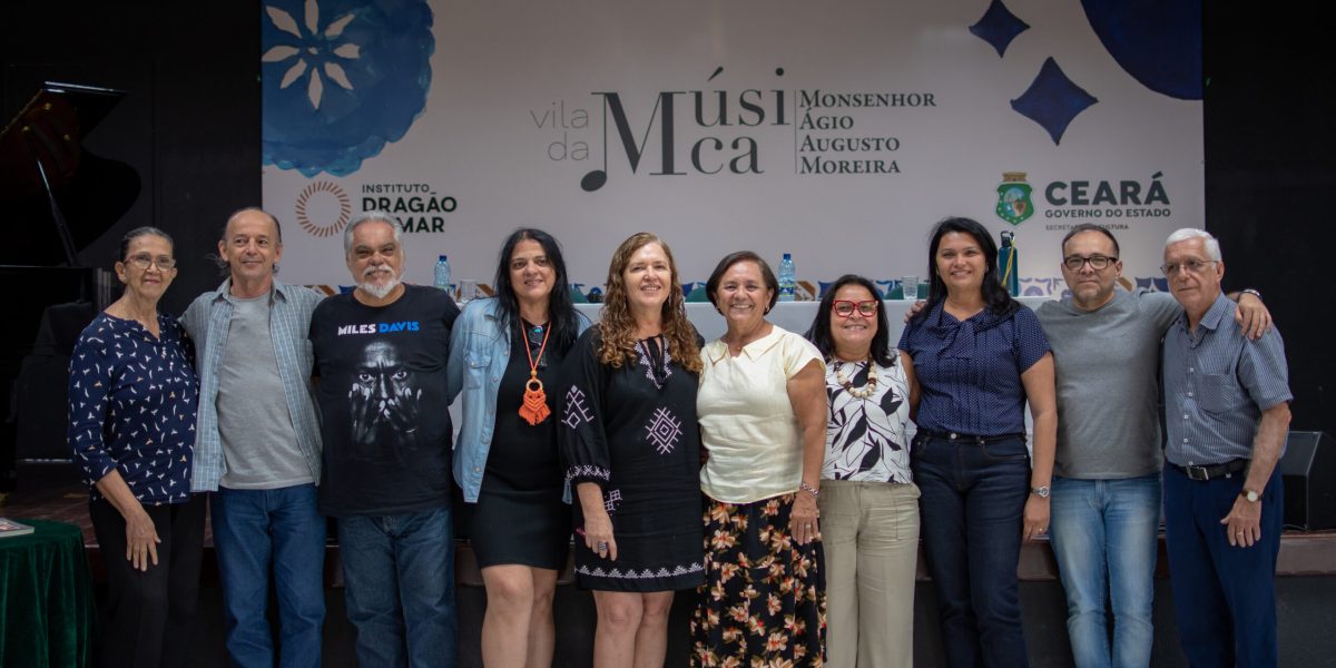 Nomes da cultura caririense e equipe da Vila da Música posam para uma foto dentro do auditório Izaíra Silvino, com o backdrop com identidade da Vila de fundo. Da esquerda do leitor, para a direita: A cordelista Josenir Lacerda, o músico João Nicodemos, o professor Marcos Leonel, a supervisora de programação da Vila da Música Mônica Vitoriano, a coordenadora de formações completares Maria Carvalho, a escritora Maria Loureto, a gestora da Vila Lucinha Rodrigues, a secretária municipal de cultura do Crato Fabiana Vieira, o assessor administrativo Mano Grangeiro e o médico e aluno da Vila da Música Dr. Marcos Cunha.