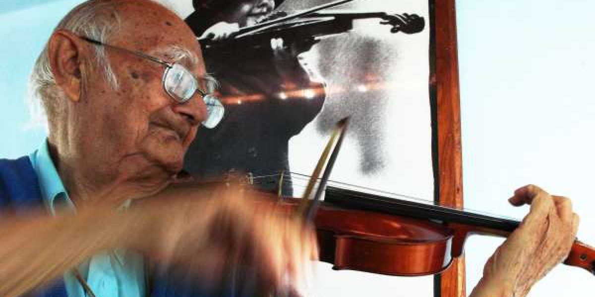 Padre Ágio tocando um violino. Foto de Pachelly Jamacaru